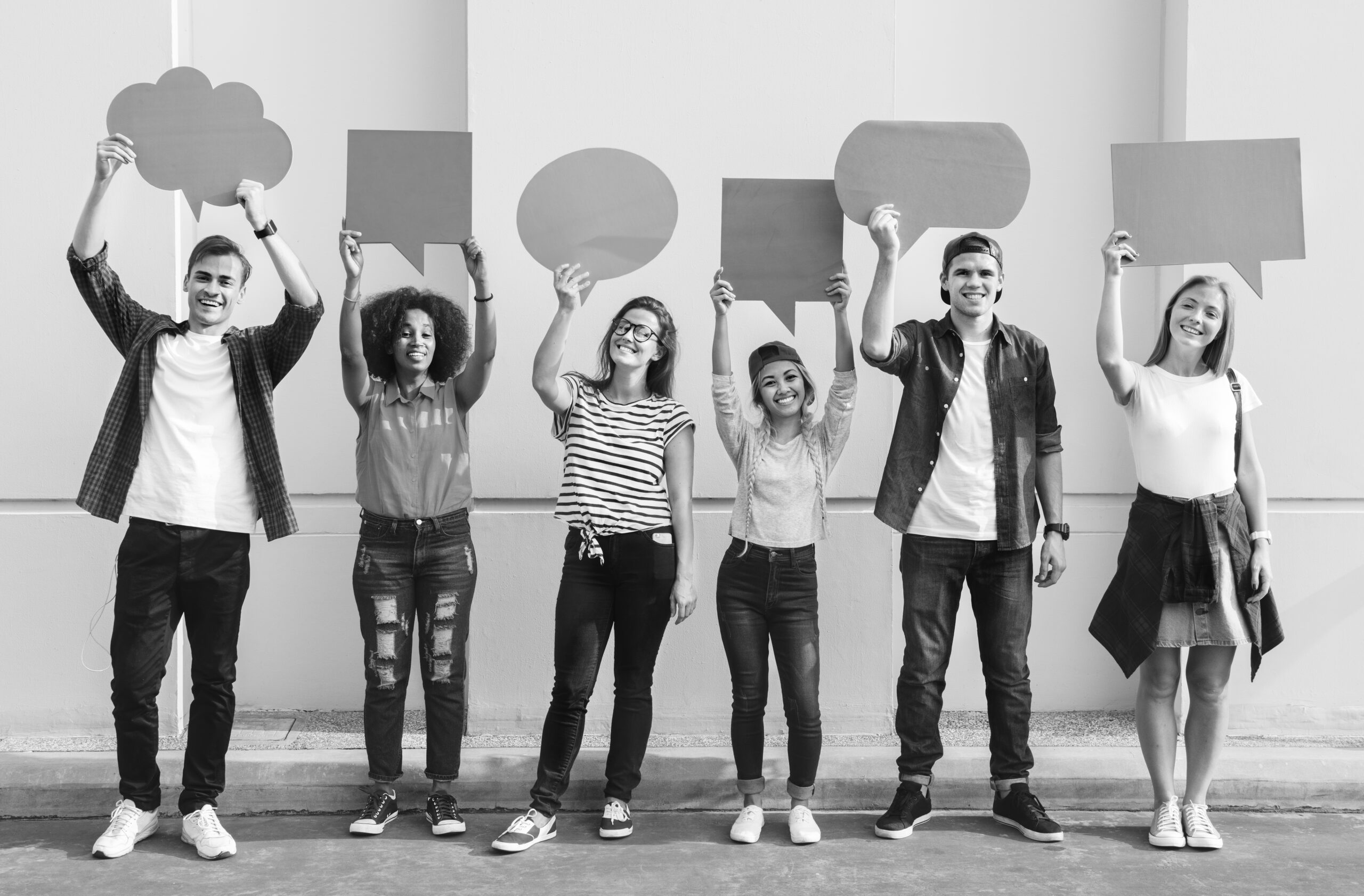 Young adult friends holding up copyspace placard thought bubbles